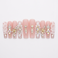 Pink floral and crystal designer nails on a white background without the case